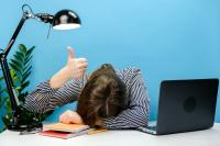 Tired exhausted woman in shirt sitting work sleep laid her head down on office desk with laptop show thumb up gesture ironically